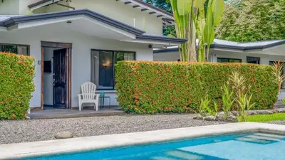 a house with a swimming pool in front of a house at Tropical 3 Cozy Cabins with Pool in Central Uvita in Uvita