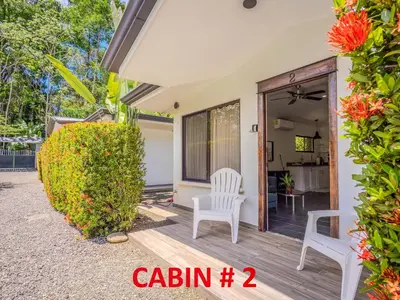 a villa with a garden and a chair on a porch at Tropical 3 Cozy Cabins with Pool in Central Uvita in Uvita