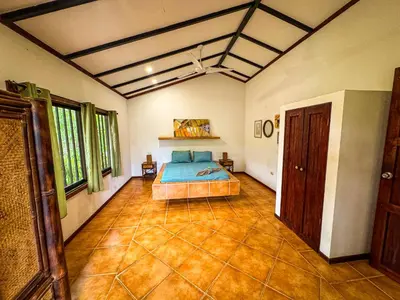 a bedroom with a bed in the middle of a room at Rustic Tropical Retreat with Pool & Garden Ojochal in Ojochal