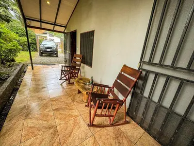 a porch with two chairs and a cat sitting on it at Rustic Tropical Retreat with Pool & Garden Ojochal in Ojochal