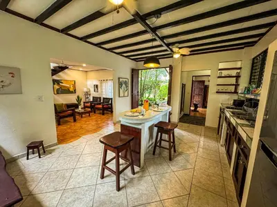 a kitchen with a counter and stools in a room at Rustic Tropical Retreat with Pool & Garden Ojochal in Ojochal