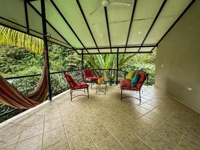 a screened in porch with chairs and a table at Rustic Tropical Retreat with Pool & Garden Ojochal in Ojochal