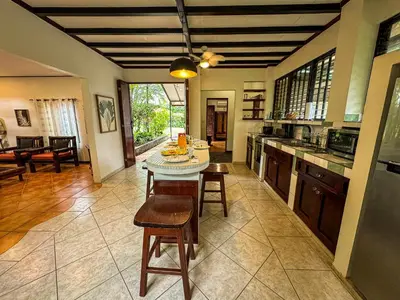 a kitchen with a table and chairs in a room at Rustic Tropical Retreat with Pool & Garden Ojochal in Ojochal