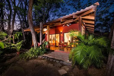 a house with a wooden porch in the woods at Casa Rustica 1 in Playa Grande