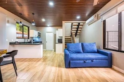a living room with a blue couch and a kitchen at Montedonato 18 - Combo in Playa Avellana