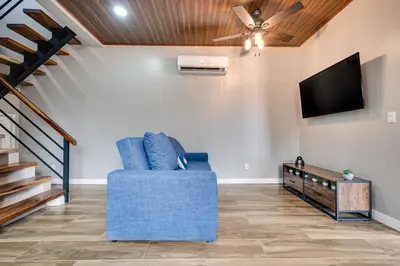 a living room with a blue chair and a flat screen tv at Montedonato 18 - Combo in Playa Avellana