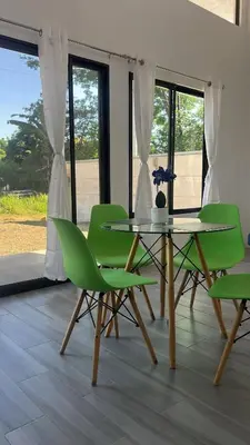 a dining room with green chairs and a table at Villas del sol in Uvita