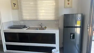 a small kitchen with a sink and a refrigerator at Villas del sol in Uvita