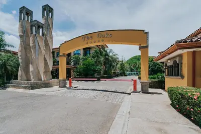 a building with a sign that reads the oasis at 2 beds -2 baths condos near Tamarindo Beach in Tamarindo