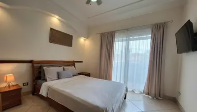 a bedroom with a bed and a large window at 2 beds -2 baths condos near Tamarindo Beach in Tamarindo