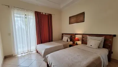 a hotel room with two beds and a window at 2 beds -2 baths condos near Tamarindo Beach in Tamarindo