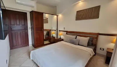 a bedroom with a large white bed and a door at 2 beds -2 baths condos near Tamarindo Beach in Tamarindo