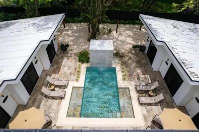 an overhead view of a pool with chairs and umbrellas at Le MaGil Boutique Hotel in Tamarindo