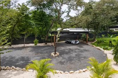 a gravel driveway with a tree in the middle at Le MaGil Boutique Hotel in Tamarindo