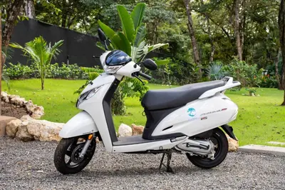 a white scooter parked on a gravel road at Le MaGil Boutique Hotel in Tamarindo