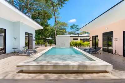 a swimming pool in the middle of a house at Le MaGil Boutique Hotel in Tamarindo