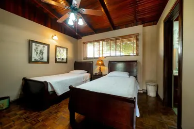 a bedroom with two beds and a ceiling fan at Casa Cres, Beachfront, Private Pools, Tennis and AC! in El Roble