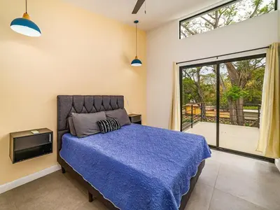 a bedroom with a blue bed and a sliding glass door at The Wave House in Santa Cruz