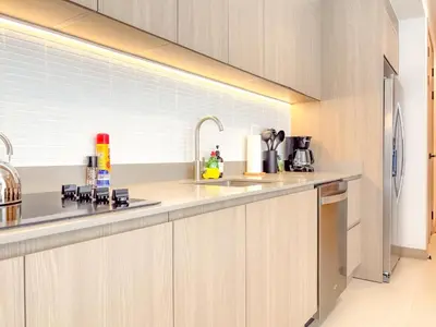 a kitchen with a sink and a refrigerator at Sol Haven at Naumi, Pools, Gym & Beach Club in Sardinal