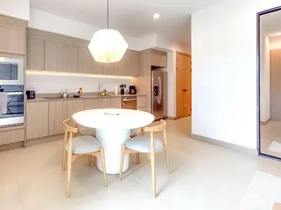 a kitchen with a white table and chairs at Sol Haven at Naumi, Pools, Gym & Beach Club in Sardinal