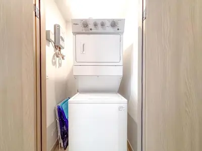 a small white refrigerator in a small room at Sol Haven at Naumi, Pools, Gym & Beach Club in Sardinal
