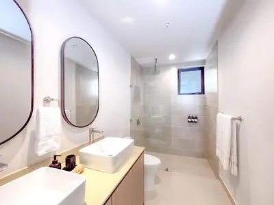 a white bathroom with a sink and a mirror at Sol Haven at Naumi, Pools, Gym & Beach Club in Sardinal