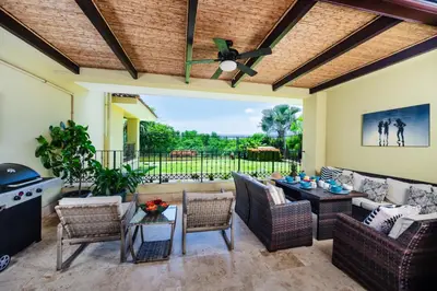 a patio with a couch and chairs and a table at Stunning Remodeled Beachfront Condo! in Tamarindo