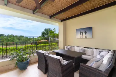 a patio with a couch and a table and chairs at Stunning Remodeled Beachfront Condo! in Tamarindo