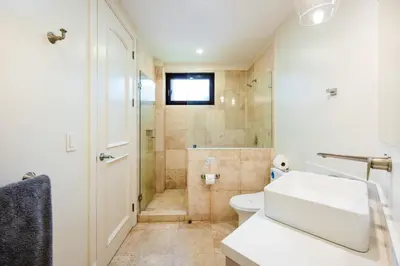 a bathroom with a sink and a toilet and a shower at Stunning Remodeled Beachfront Condo! in Tamarindo