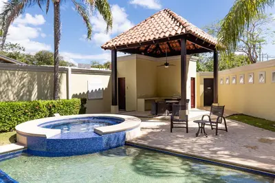 a backyard with a pool and a gazebo at Stunning Remodeled Beachfront Condo! in Tamarindo