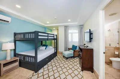 a bedroom with a bunk bed and a bathroom at Stunning Remodeled Beachfront Condo! in Tamarindo