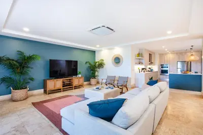 a living room with a white couch and a tv at Stunning Remodeled Beachfront Condo! in Tamarindo
