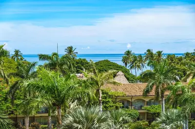 a resort with palm trees and the ocean in the background at Beautiful Ocean View Condo Steps to the Beach in Tamarindo