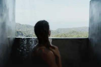 a woman looking out of a window at the mountains at Finca Renacer - Jungle Lodges in San Luis