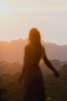 a woman standing in front of the sunset at Finca Renacer - Jungle Lodges in San Luis