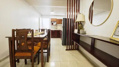 a dining room with a table and a mirror at Casa Sambola in Tortuguero