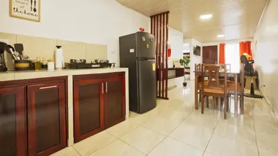 a kitchen with a refrigerator and a table and chairs at Casa Sambola in Tortuguero