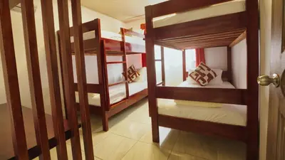 a room with two bunk beds and a door at Casa Sambola in Tortuguero