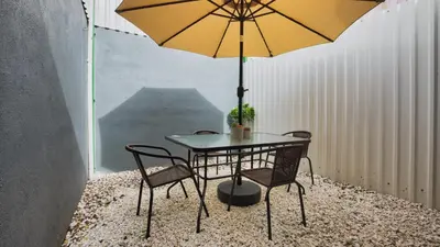 a table and chairs with a yellow umbrella at Casa Sambola in Tortuguero