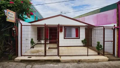 a house with a gate in front of a building at Casa Sambola in Tortuguero