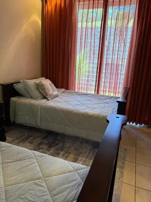 a bedroom with two beds and a large window at Casa Esperanza Luxury Villa in Esterillos Este