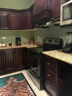 a kitchen with wooden cabinets and a black stove at Casa Esperanza Luxury Villa in Esterillos Este
