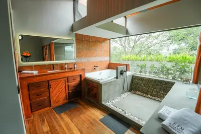 a bathroom with a tub and a sink and a mirror at Private Wellness Home Sauna, Jacuzzi &Cold Plunge in Brasil