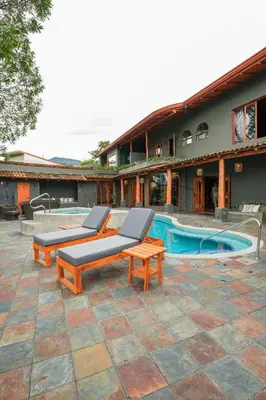 a patio with two lounge chairs and a pool at Private Wellness Home Sauna, Jacuzzi &Cold Plunge in Brasil