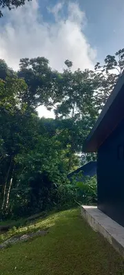 a blue house with trees in the background at Bosquelago houserental in Tronadora