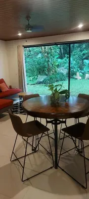a table and chairs in a room with a large window at Bosquelago houserental in Tronadora