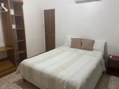 a bedroom with a large bed with white sheets at Casitas Diquis in Ojochal