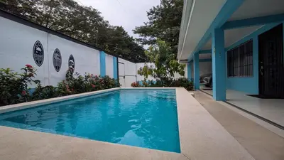 a swimming pool in front of a house at Casa Azul Tropical Poolside Oasis in Sámara in Sámara