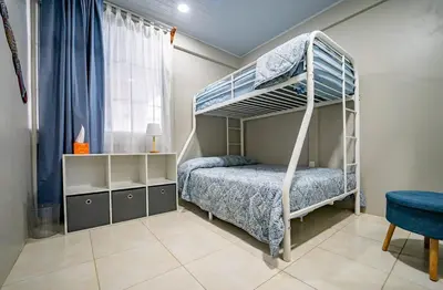 a bedroom with a bunk bed and a blue chair at Casa Azul Tropical Poolside Oasis in Sámara in Sámara