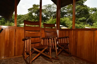 two wooden rocking chairs sitting on a porch at Hacienda Baru in Dominical